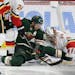 Calgary Flames goalie David Rittich (33) makes a stop on Minnesota Wild left wing Zach Parise (11) in the third period during an NHL hockey game Sunda