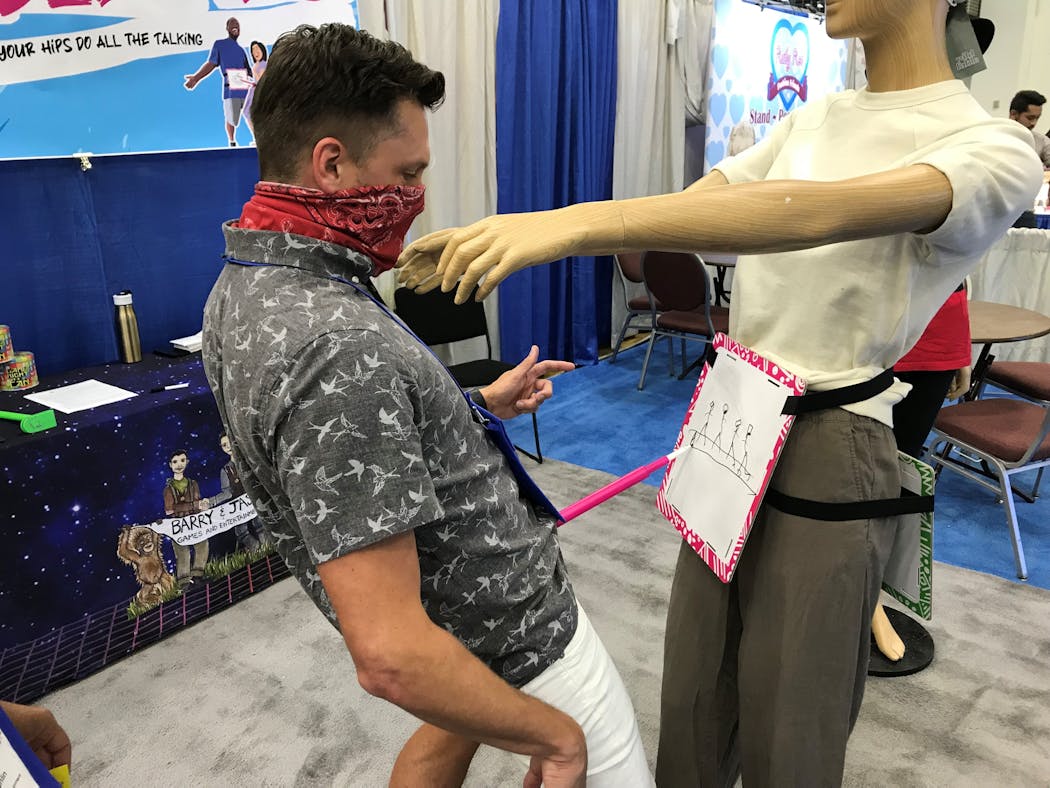 A game maker demonstrates Scribble Hips, a hands-free drawing game, at the American Specialty Toy Retailers convention in Minneapolis.
