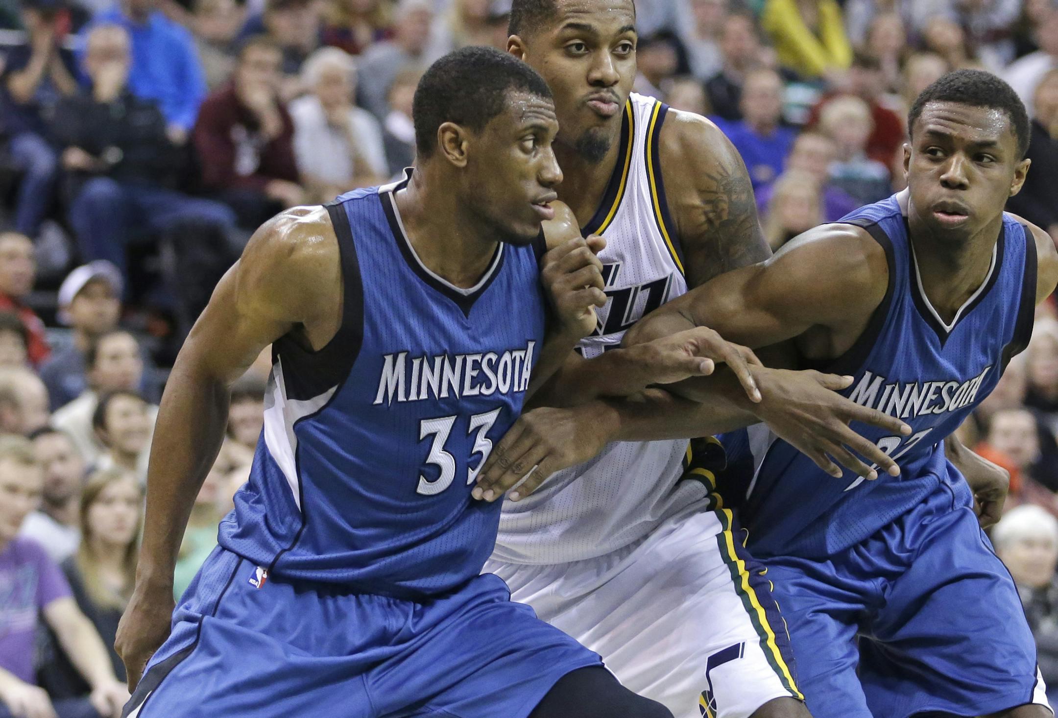 Minnesota Timberwolves forward Thaddeus Young (33) and forward Andrew Wiggins, right, battle under the boards with Utah Jazz forward Derrick Favors, center, in the second half during an NBA basketball game Tuesday, Dec. 30, 2014, in Salt Lake City. (AP Photo/Rick Bowmer)