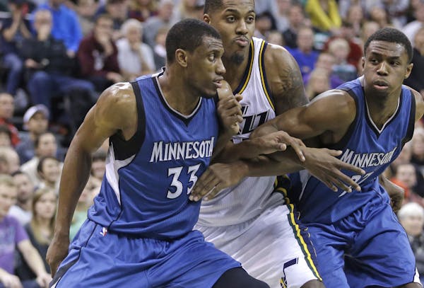 Minnesota Timberwolves forward Thaddeus Young (33) and forward Andrew Wiggins, right, battle under the boards with Utah Jazz forward Derrick Favors, c