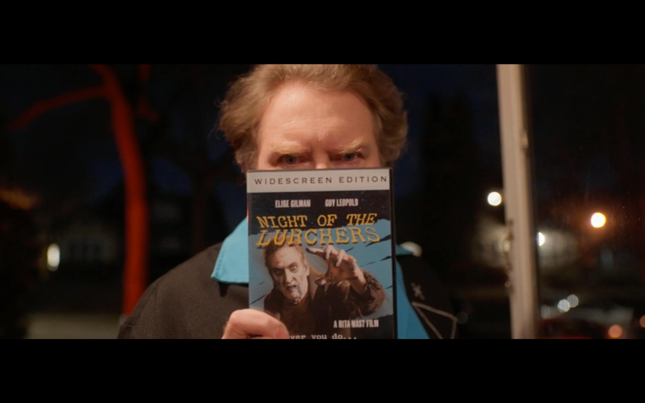 photo of a man holding a DVD to the camera