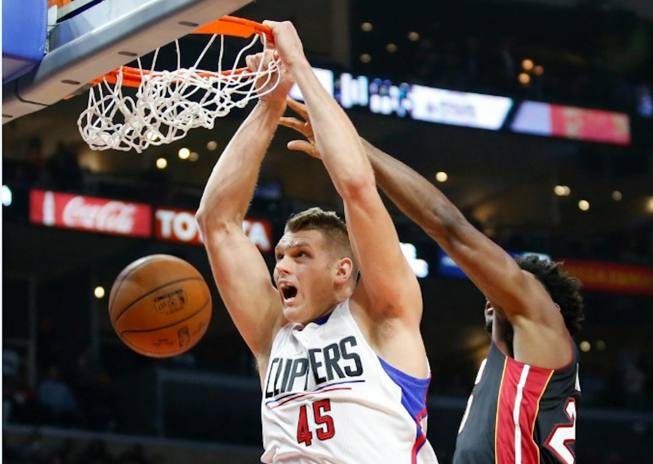Los Angeles Clippers' Cole Aldrich, left, dunks past Miami Heat's Justise Winslow during the first half of an NBA basketball game Wednesday, Jan. 13, 2016, in Los Angeles.