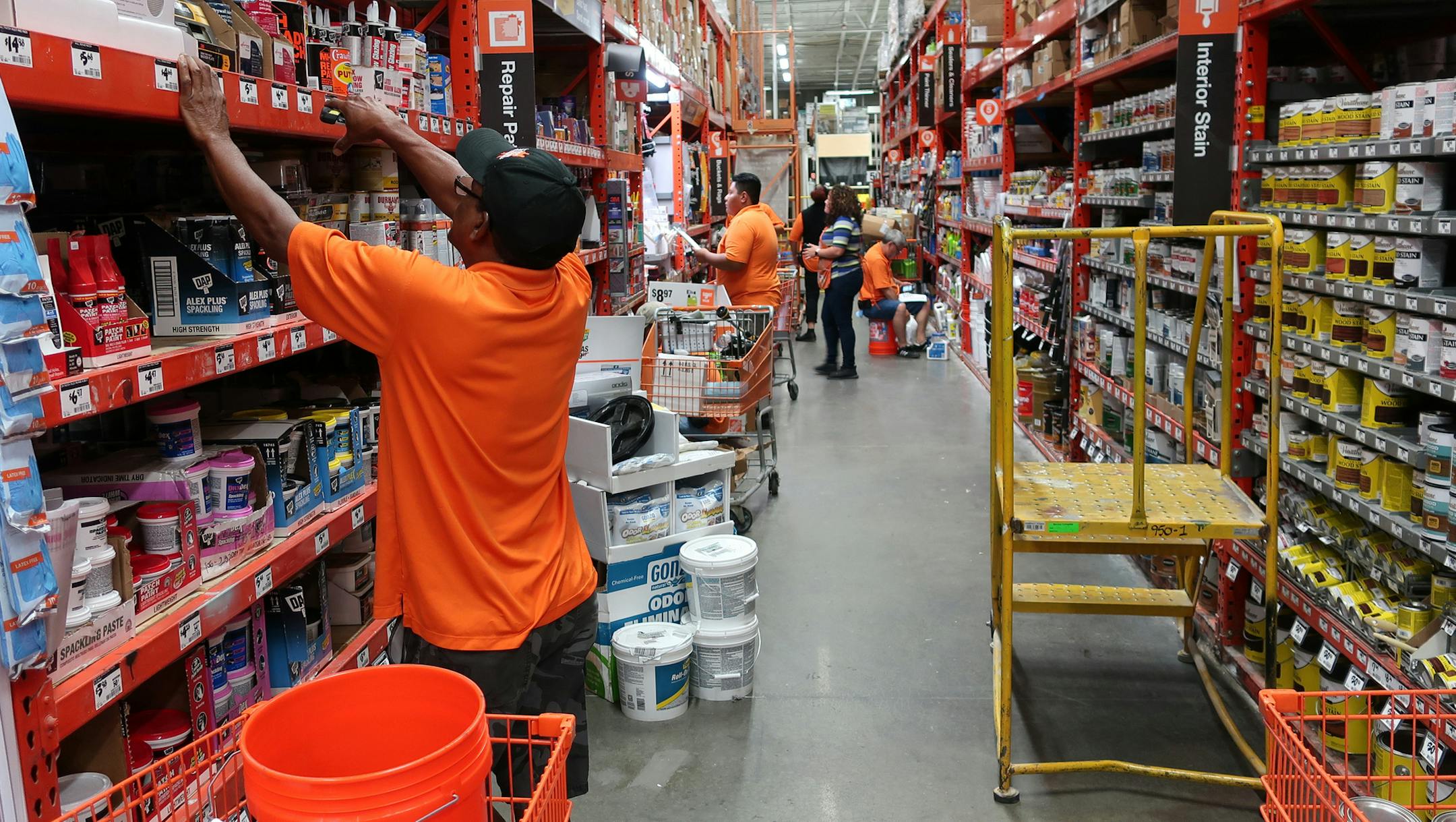 FILE- In this Aug. 14, 2018, file photo workers stock the shelves at a Home Depot store in Passaic, N.J. Home Depot Inc. reports financial results Tuesday, Feb. 26, 2019. (AP Photo/Ted Shaffrey, File)