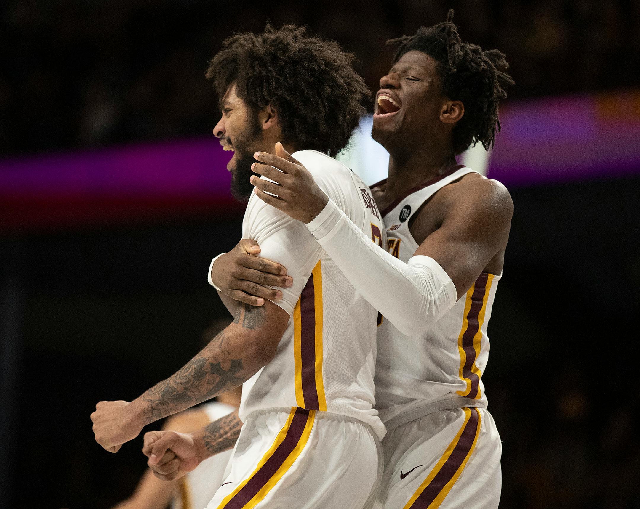 Jordan Murphy, left, and Daniel Oturu celebrate after Murphy scored against Purdue on Tuesday