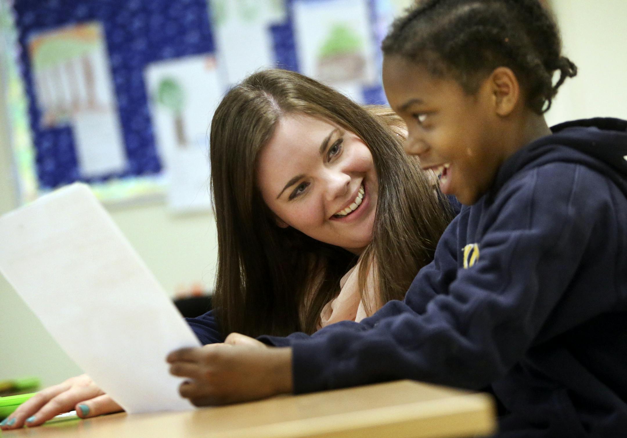 Samantha Ovadal, an EA at John Glenn Alternative Program with a bachelor's degree in sociology, listens to a student in a K-5 class talk about a superhero he created for a class project Tuesday, April 22, 2014, at John Glenn Alternative Learning Program in Maplewood, MN. Ovadal will be heading to the U of M in the fall to earn a Master's degree in education while working as an EA at the school to combat a state shortage of special education teachers that often causes schools to put unqualified t