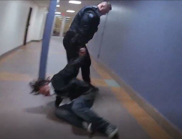 A screengrab from an officer's bodycam video shows Duluth police officer Adam Huot dragging a man by his handcuffs.