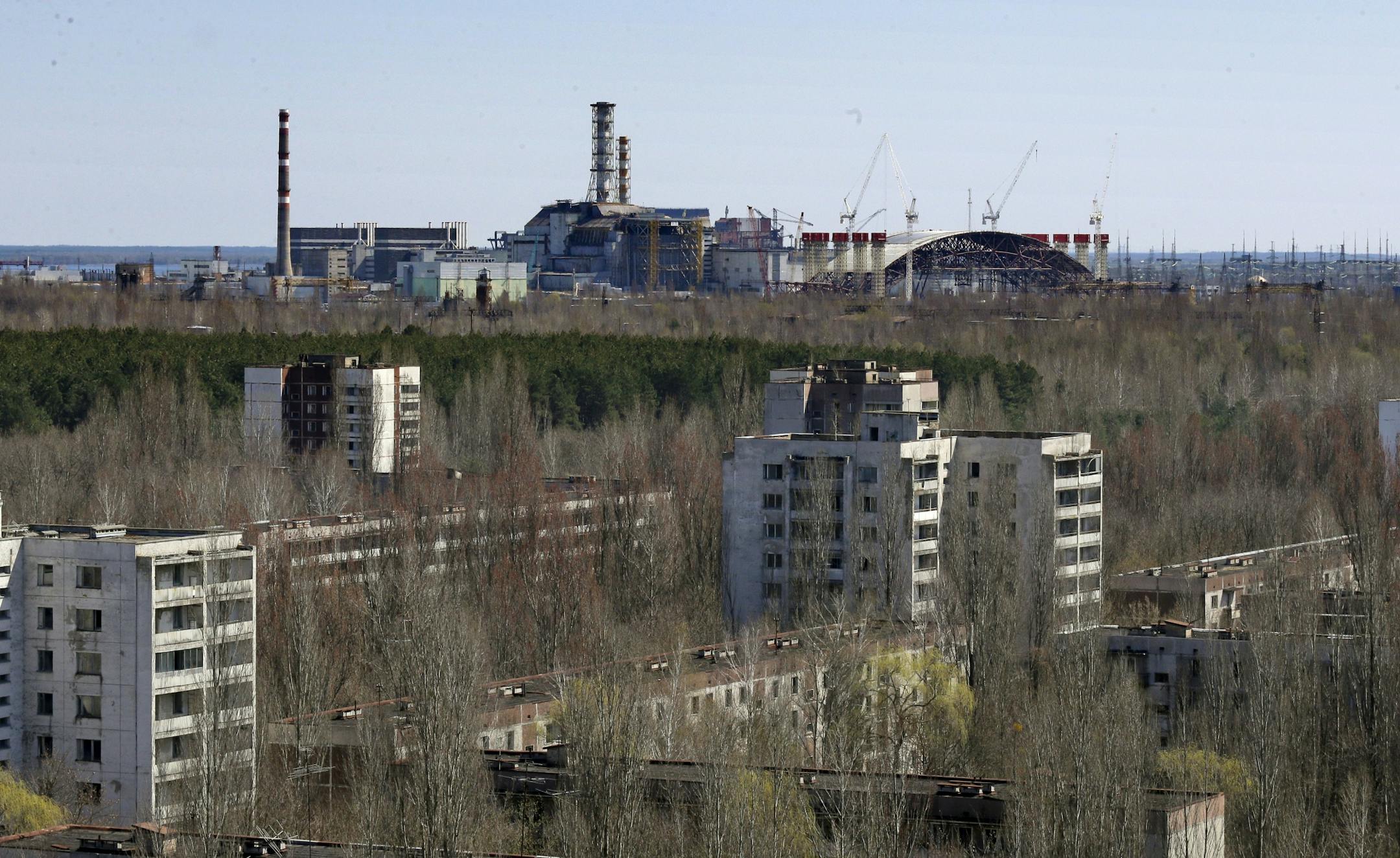 The town of Prypyat is seen against the background of the damaged reactor at the Chernobyl nuclear power plant in Prypyat, Ukraine, Tuesday, April 23, 2013. At background right is a gigantic steel-arch under construction to cover the remnants of the exploded reactor. Ukraine marks the 27th anniversary of the world's worst nuclear disaster on April 26.