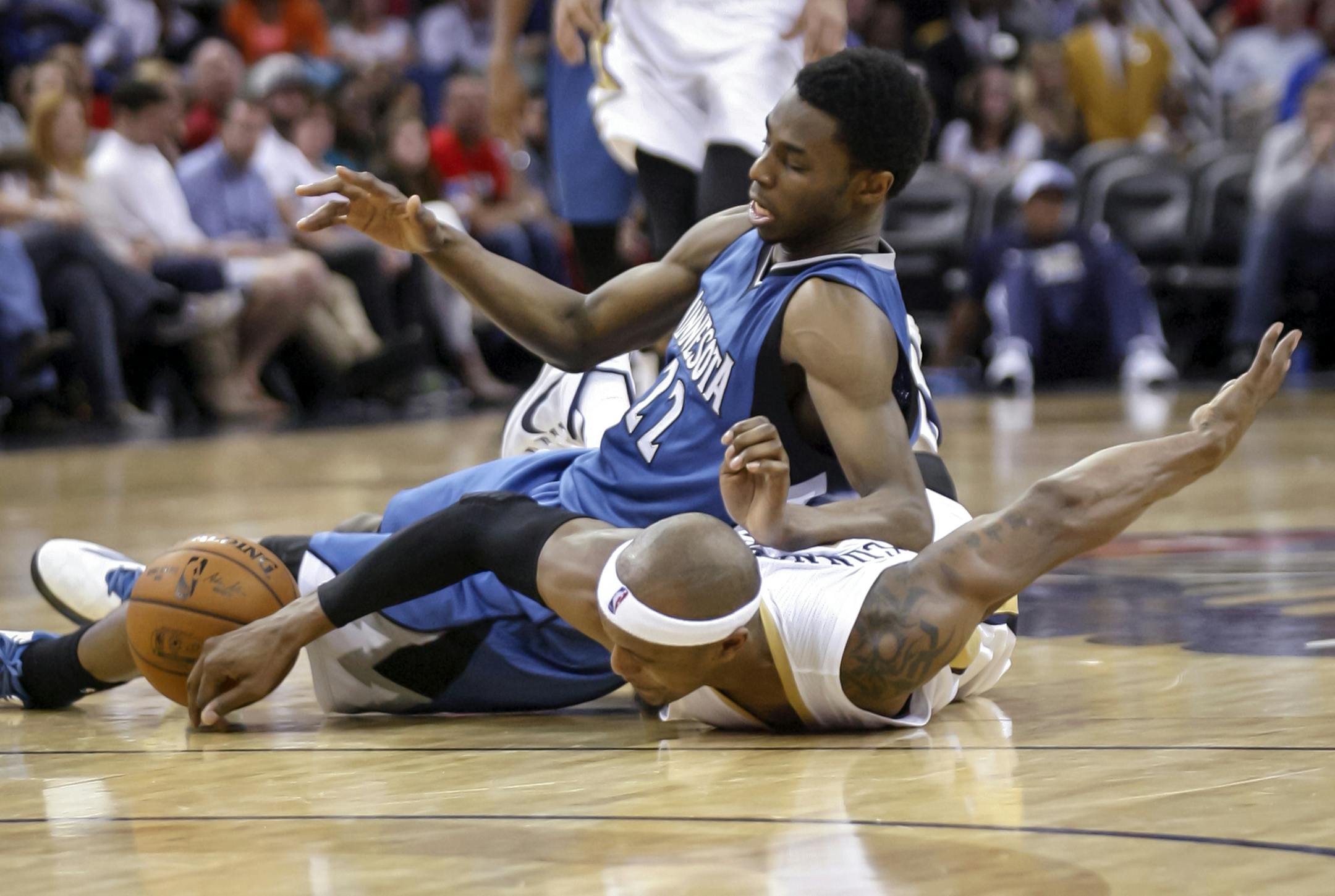 Minnesota Timberwolves forward Andrew Wiggins (22) and New Orleans Pelicans forward Dante Cunningham (44) scramble for a loose ball during the second half of an NBA basketball game in New Orleans, Sunday, March 29, 2015. The Pelicans won 110-88. (AP Photo/Scott Threlkeld)