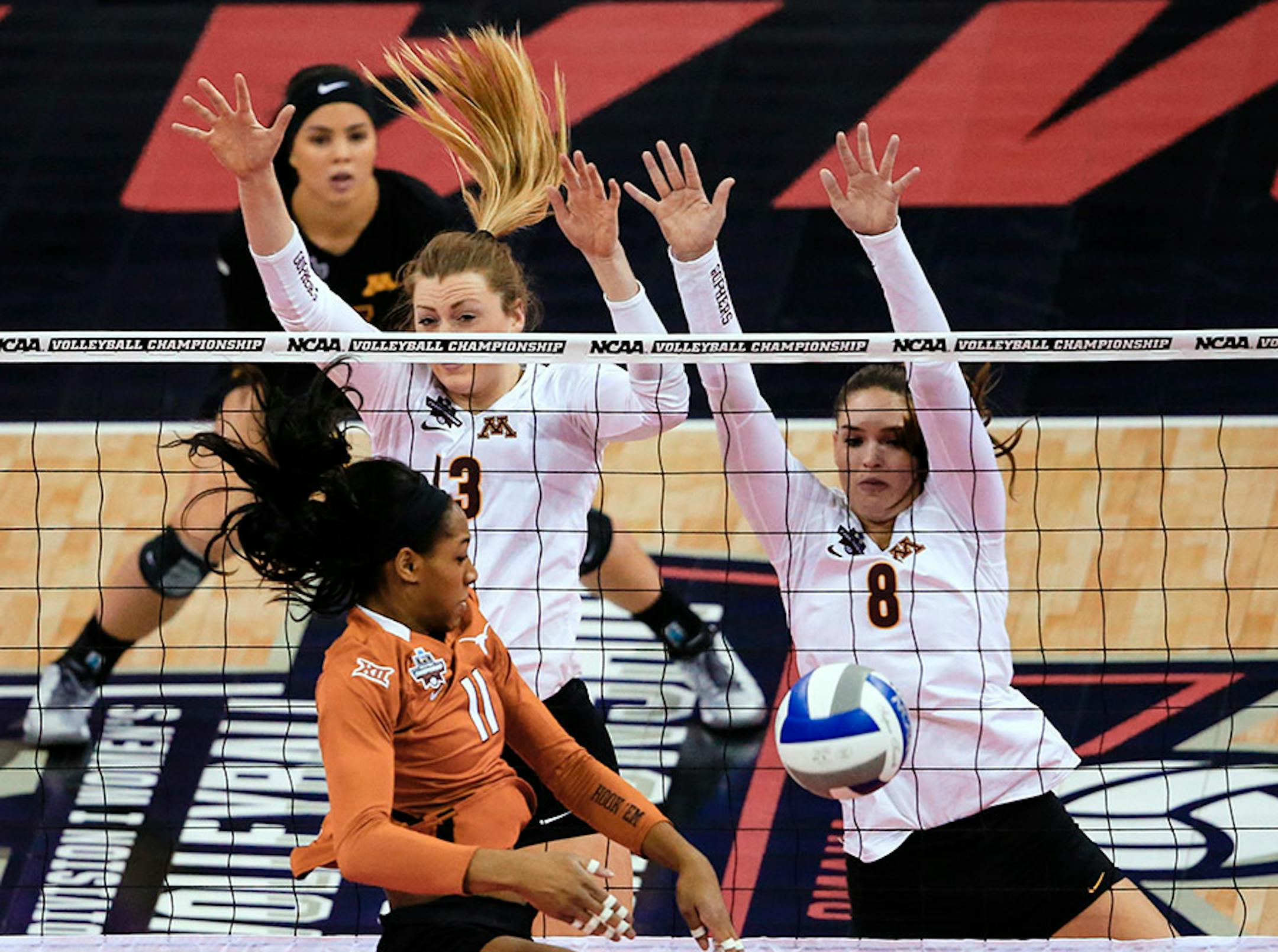 Minnesota's Molly Lohman (13) and Sarah Wilhite (8) block a kill attempt by Texas' Chiaka Ogbogu (11) during an NCAA women's volleyball tournament semifinal in Omaha, Neb., Thursday, Dec. 17, 2015.