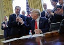 FILE - In this Feb. 24, 2017, file photo, President Donald Trump gives the pen he used to sign an executive order to Dow Chemical President, Chairman 