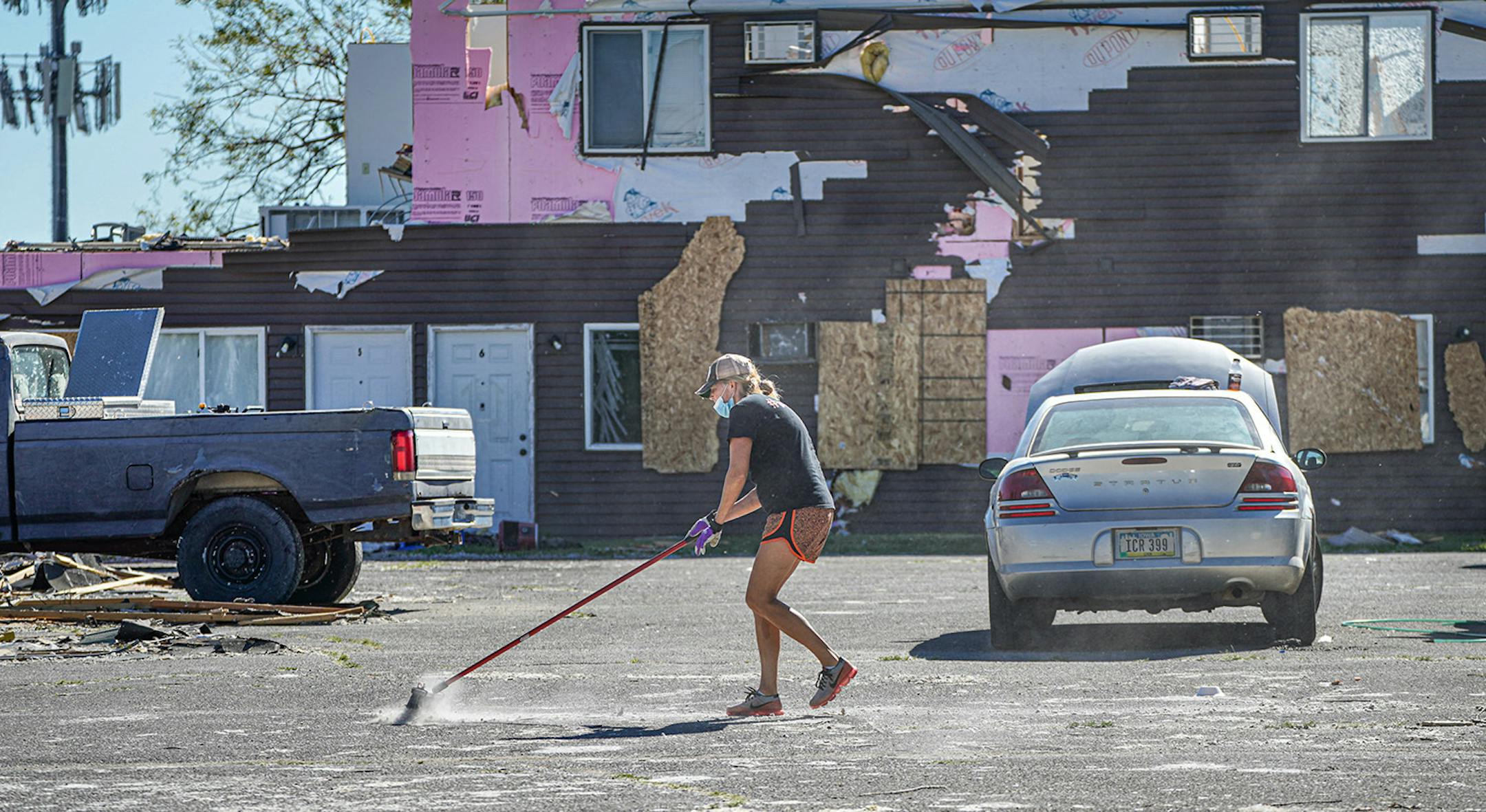 Jen Stoffer tried to sweep debris , mostly bits of insulation from damaged apartments in Cedar Rapids. School teachers from nearby Prairie Park Middle School volunteered their time to clean up storm damage in Cedar Rapids.