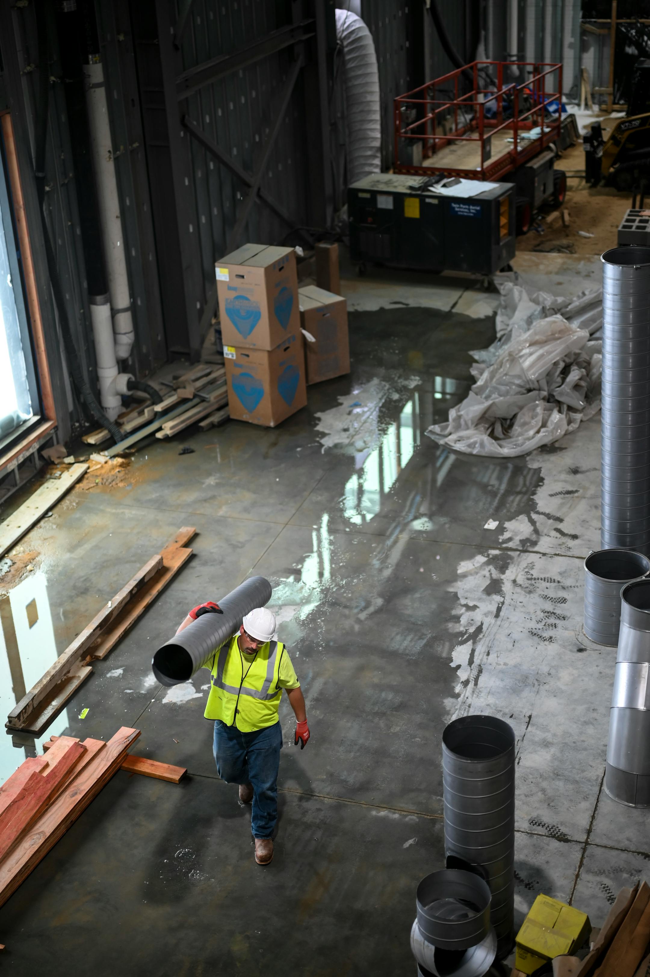 A construction worker carries a duct while working in Rock Ridge High School's new Career and Technical Education facility Tuesday, Feb. 22, 2022.