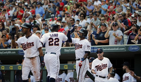 Miguel Sano (22) homers in the7th inning, scoring two runs as he is congratulated by his teammates in the dugout.