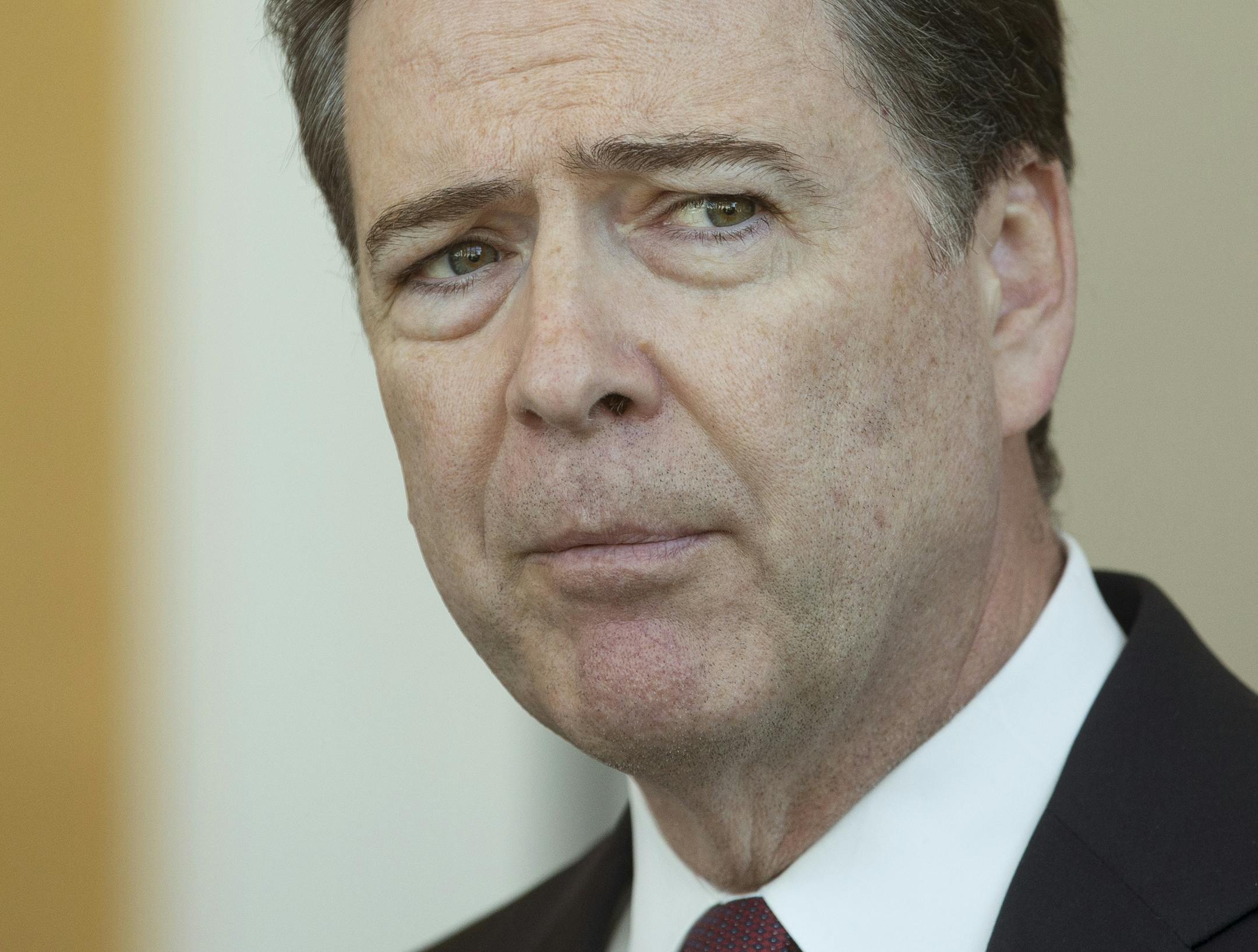 FILE - In this Wednesday, Oct. 14, 2015, file photo, FBI Director James Comey listens to a question from the media during a news conference at the FBI offices in Cincinnati. Three federal cyberstalking cases that surfaced within a few days of each other in the Cincinnati area have underscored widening challenges in protecting susceptible youths from wily predators. The three men charged all were linked to multiple girls or young women they are accused of pressuring into providing sexually explic