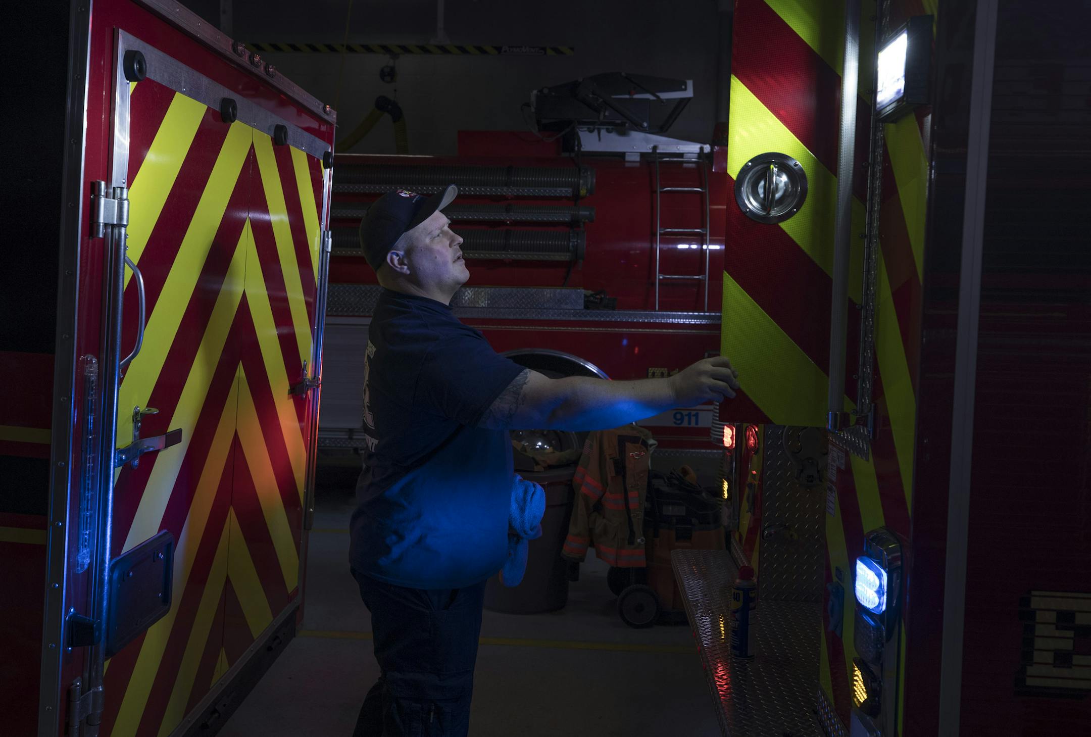 Dustin Pedersen checked a truck's lights. Fire departments across the metro are having to supplement what were once mostly volunteer staffs.