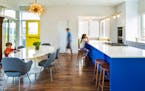 The Gardner kids in the kitchen-dining area featuring a cobalt blue center island and Sputnik-style chandelier.
