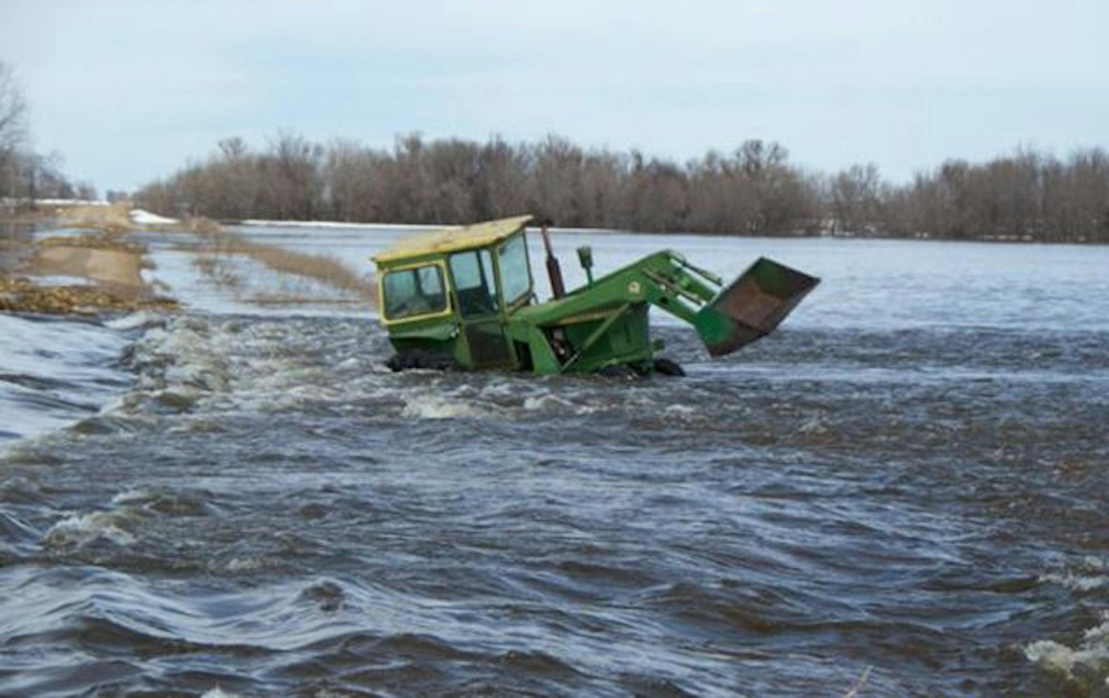 A Minnesota State Patrol trooper, supported by a Lac Qui Parle deputy, used a raft to rescue a farmer stuck in his tractor in a flooded field near Madison, Minn., in southwest Minnesota today.