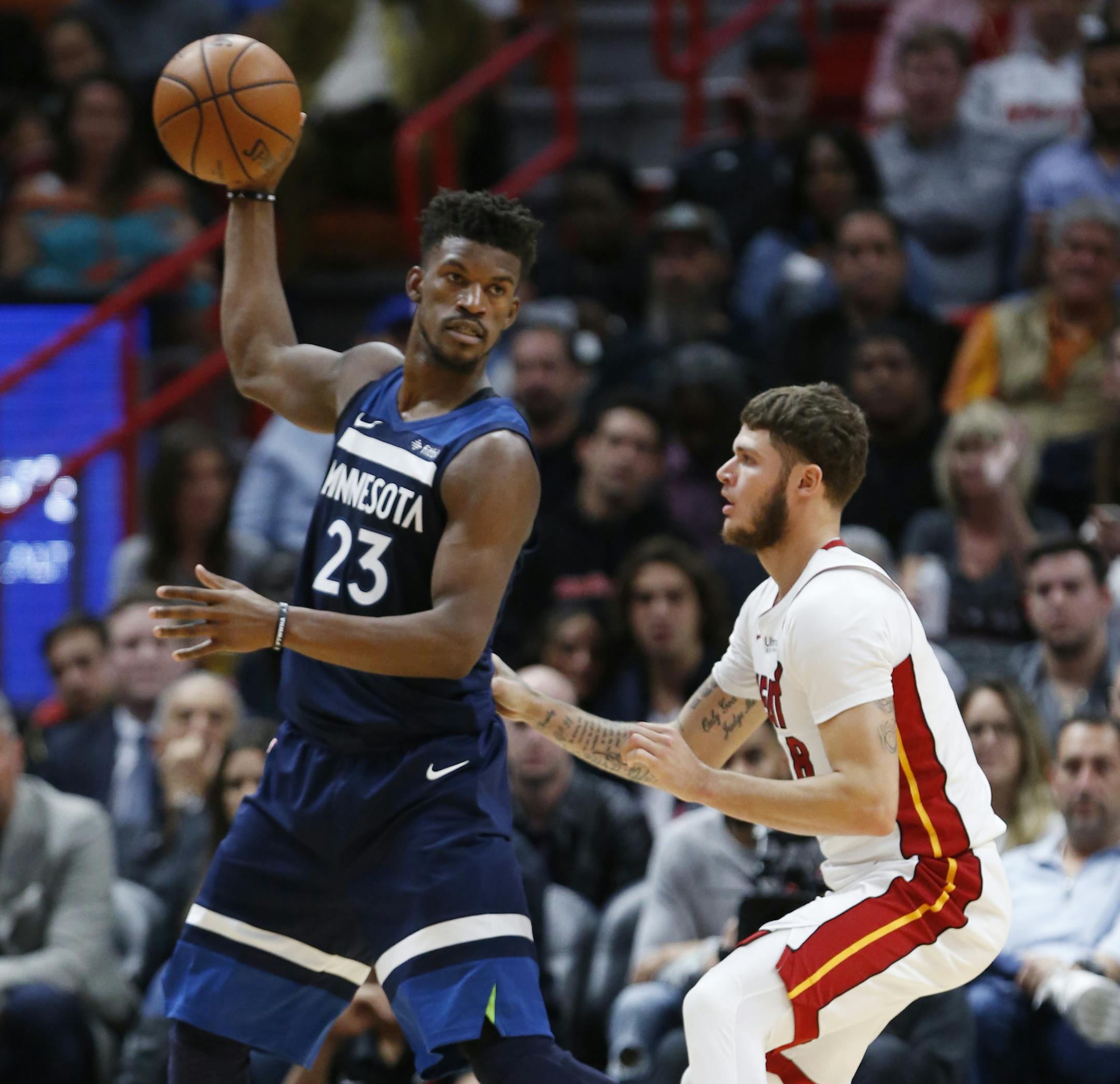 Minnesota Timberwolves forward Jimmy Butler (23) looks for an open teammate past Miami Heat guard Tyler Johnson during the second half of an NBA basketball game, Monday, Oct. 30, 2017, in Miami. The Timberwolves defeated the Heat 125-122 in overtime. (AP Photo/Wilfredo Lee)