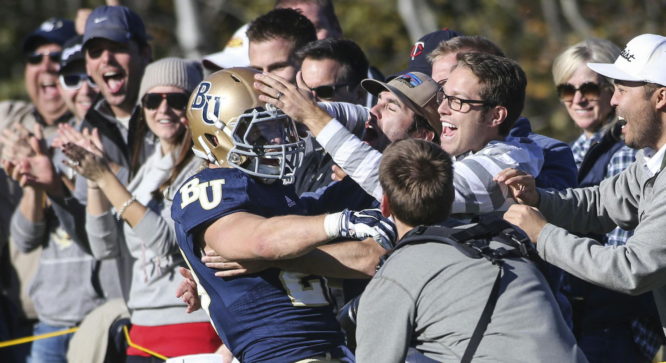 Bethel University runningback Marshall Klitzke (28) receives the adoration of fans after a fourth quarter touchdown run against the University of St. Thomas at Bethel campus stadium Saturday, Oct. 25, 2014, in Arden Hills, MN. Bethel beat St. Thomas 35-24.](DAVID JOLES/STARTRIBUNE)djoles@startribune.com