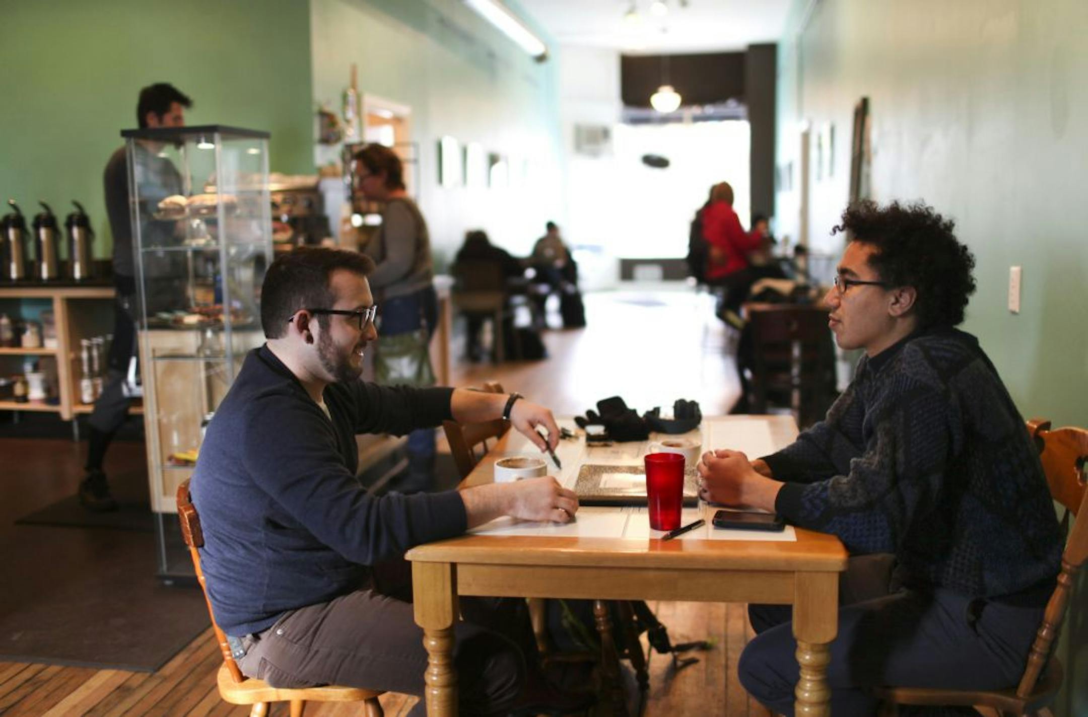 Cris Gibson, left, and Justin James, both of St. Paul, conversed over cappuccinos and lattes last week at Groundswell Coffee. "I love the vibe here," James said.