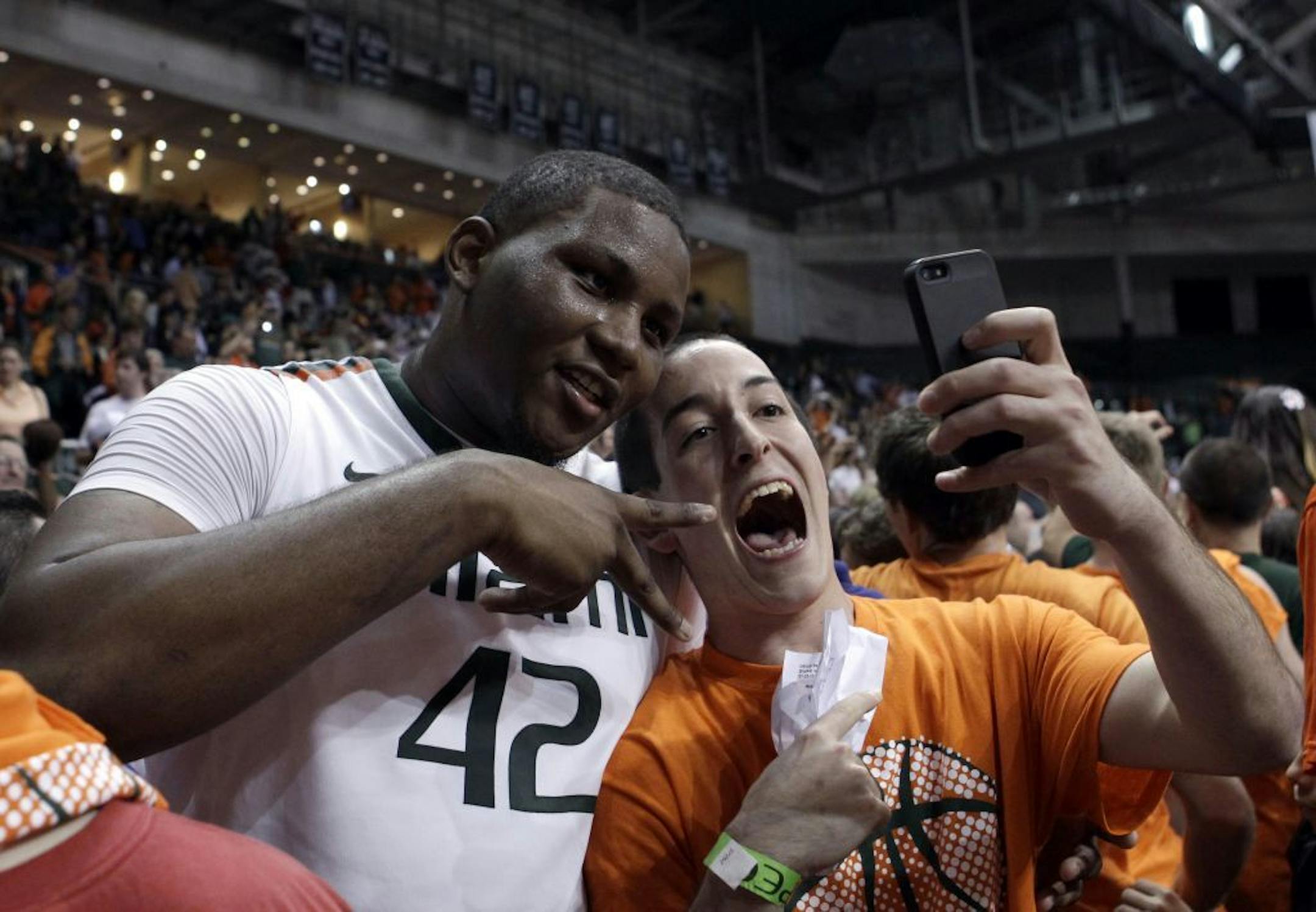 A fan takes a picture with Miami's Reggie Johnson after a 90-63 win against Duke.