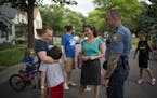Rebecca Penforl-Murray hugged her son, Peter, while visiting with St. Paul councilmember Rebecca Noecker and St. Paul Police Commander Wes Denning, wh