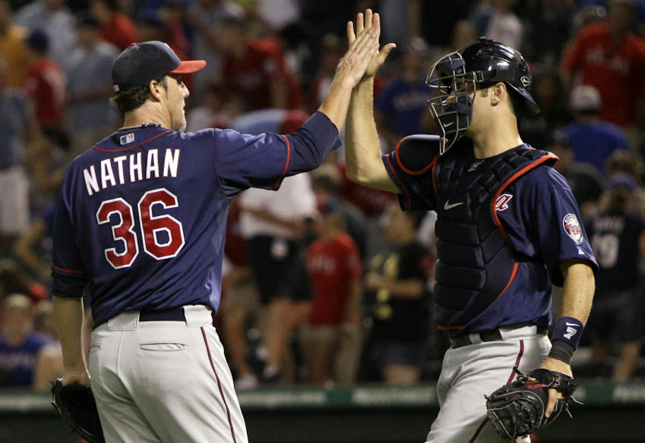 Joe Nathan and Joe Mauer celebrate after Tuesday's 9-8 win over Texas.