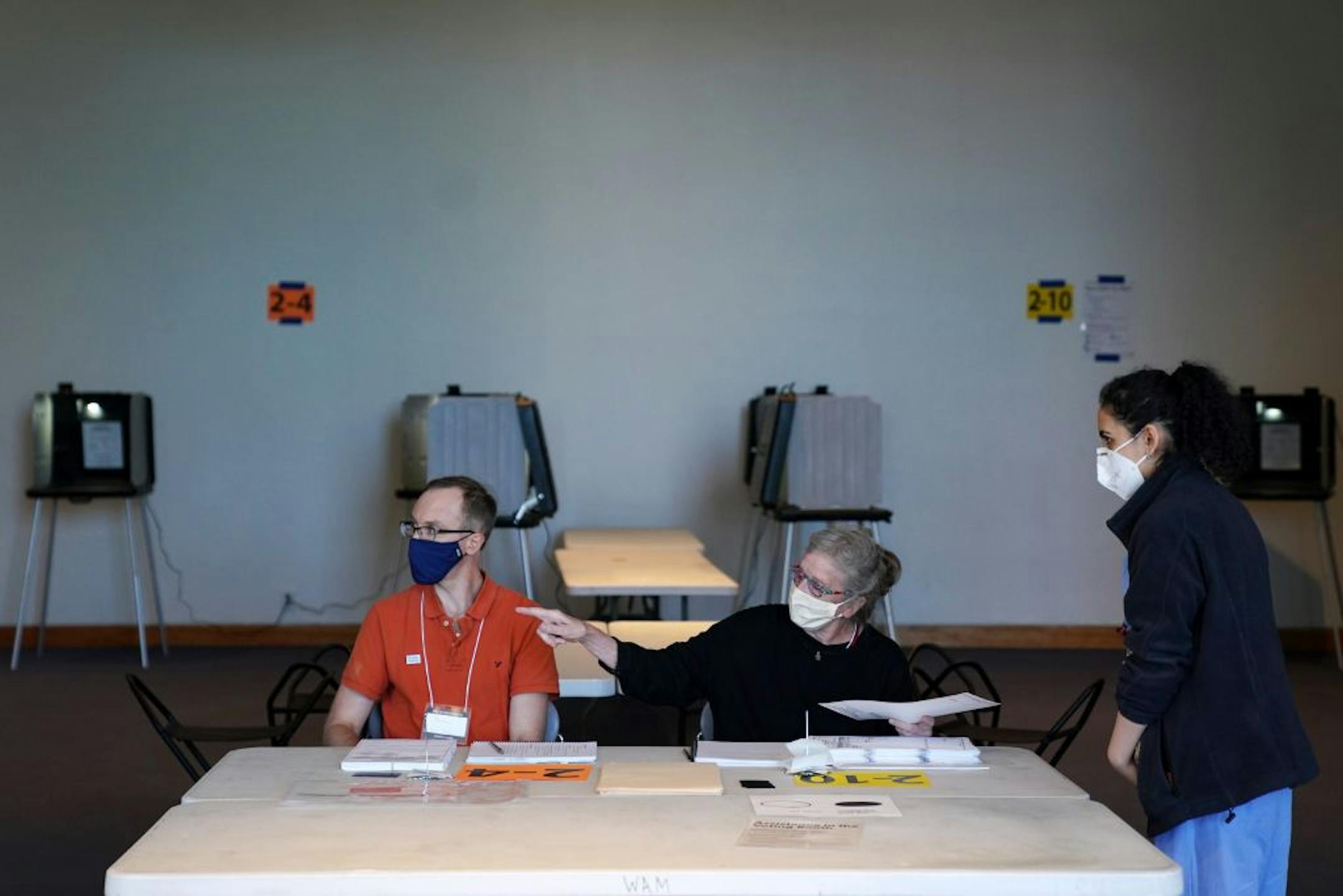 Election judges Andrew Olson, left, and Sandra Hunter, showed voter Riya Madan where to cast her ballot inside the Frederick R. Weisman Art Museum at the University of Minnesota in Minneapolis.