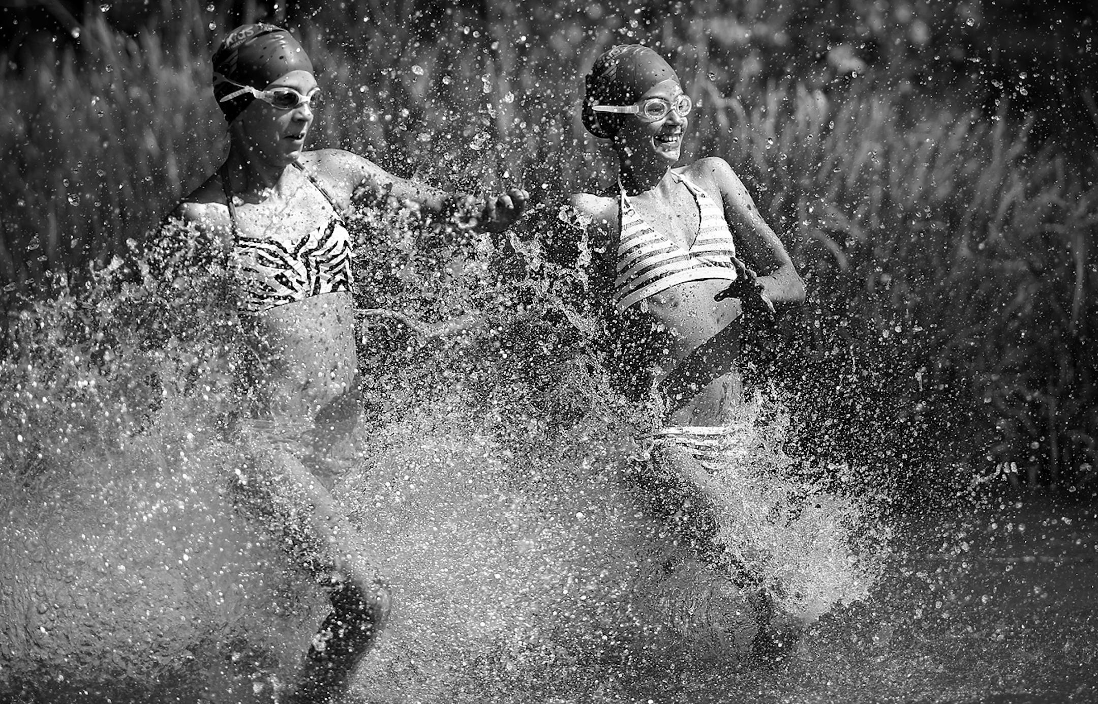 Racers splash to start the Miracle for Mitch kids triathlon at Lake Nokomis in Minneapolis, Minn., on Saturday, August 3, 2013.