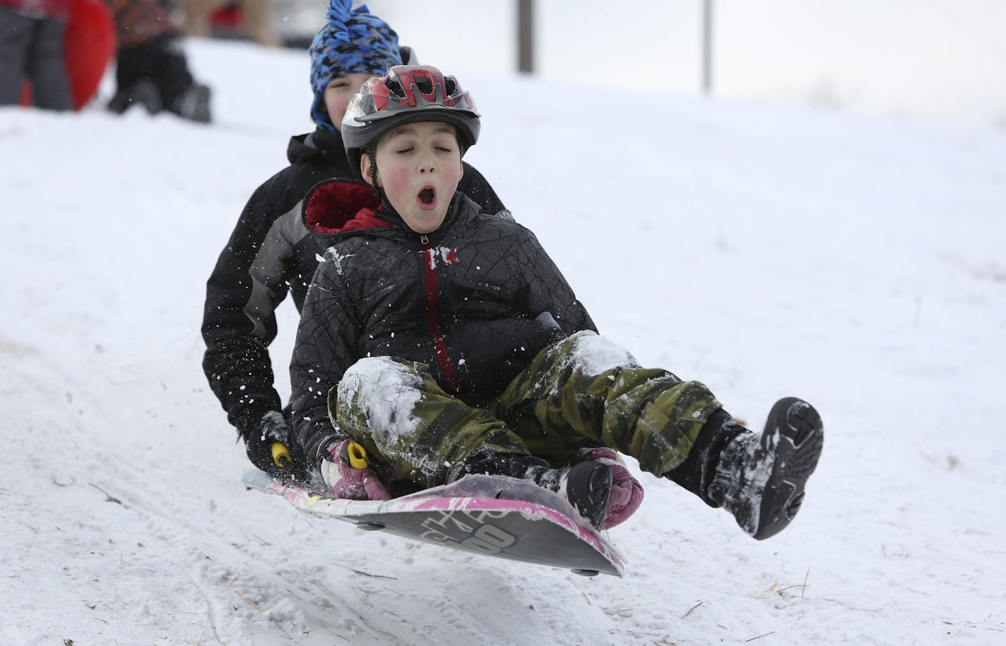 Gabe Lilienthal, 10, front and Nathan Kuklinski, 12 caught some air on a jump as Gabe wore his new helmet on the sledding hill at Lake Nokomis Park in Minneapolis, Min., Friday December 28, 2012. Children&#x201a;&#xc4;&#xf4;s Hospitals and Clinics of Minnesota and two veteran Minneapolis Police Officers participated in a Sledding Safety Flash Mob promoting wearing a helmet while sledding. ] (KYNDELL HARKNESS/STAR TRIBUNE) kyndell.harkness@startribune.com