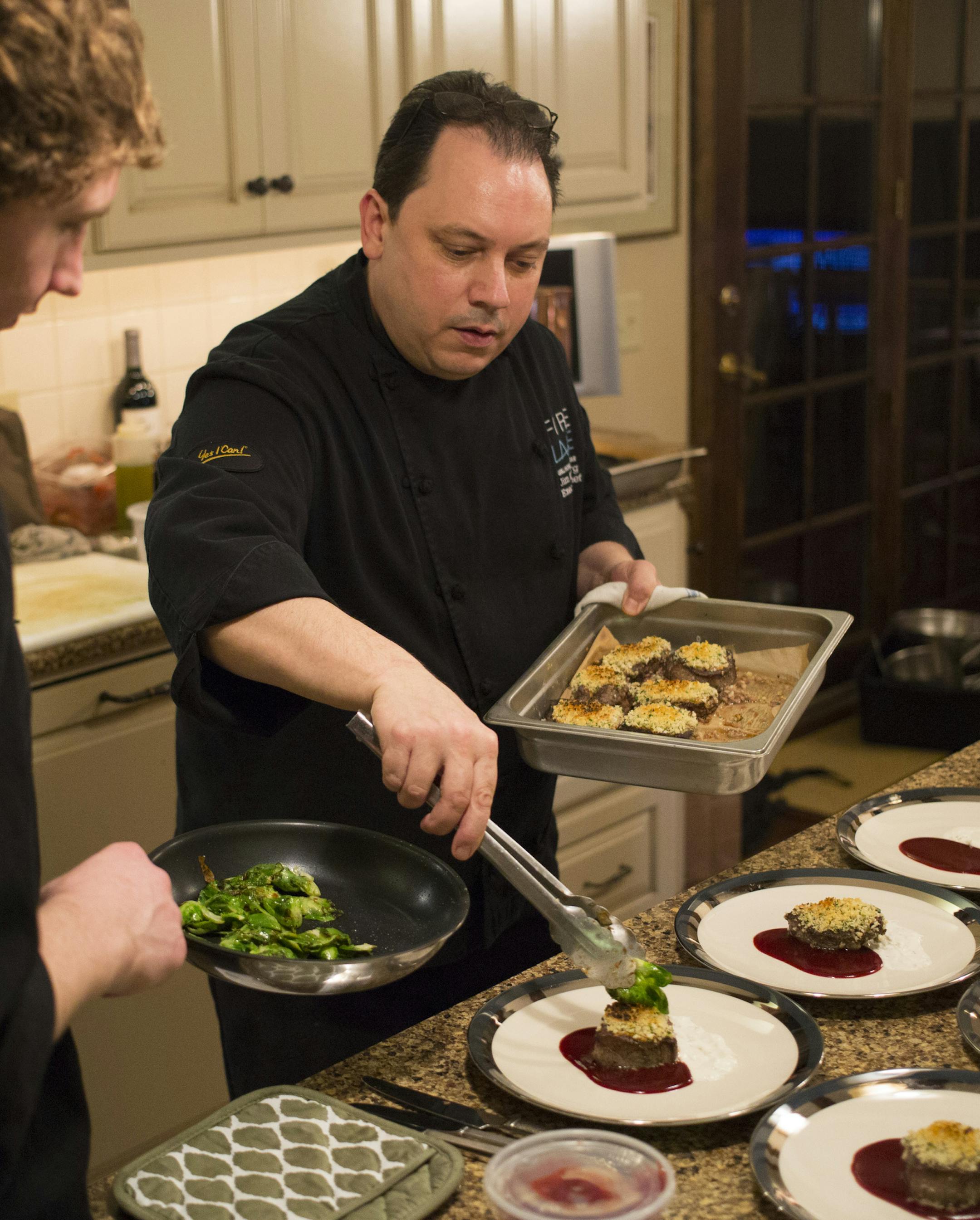 Chef Jim Kyndberg (right) prepared the main dish, Seared Elk Medallion with Potato & Celery Root Gratin and Brussels Sprouts during a wild game feast for Outdoor TV personality Ron Schara and guests. Garde MangerTanner Stoen helps at left. ] BRIAN PETERSON • brianp@startribune.com Ramsey, MN - 2/25/2015