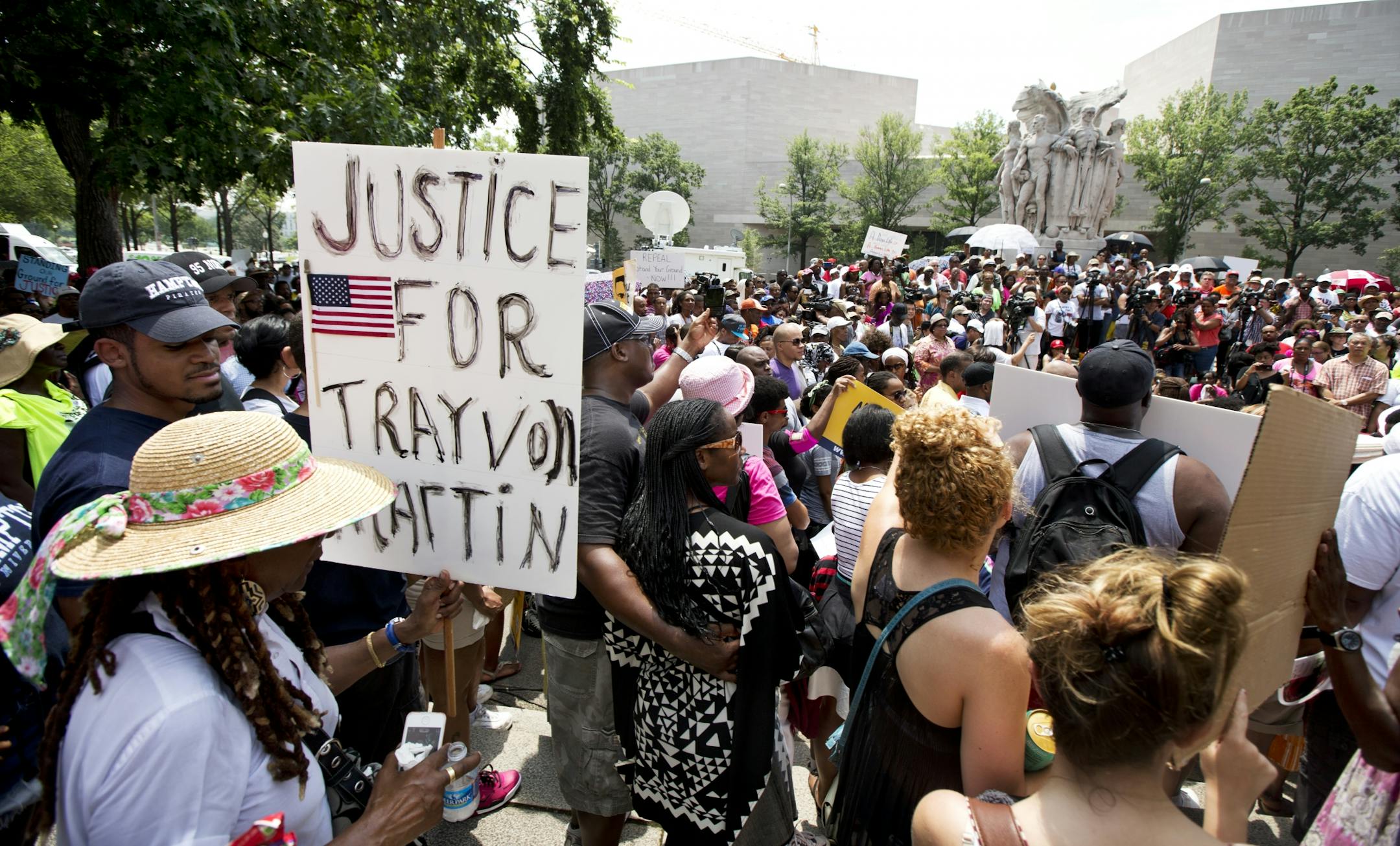 People gather in front of the federal court in Washington Saturday, July 20, 2013, as they demonstrate in the "Justice for Trayvon -100 City Vigil". Friday, just before the scheduled vigils and rallies in 100 U.S. cities, President Barack Obama spoke about the raw reaction to the acquittal in a Florida court of the man who shot and killed 17-year-old Trayvon Martin. Saying "Trayvon Martin could have been me, 35 years ago," Obama said he had to speak because America needs to understand why so man