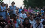 Ruben Vazquez of New Brighton, front left, sat with daughter Jasmine Vazquez-Matze, 12, during a moment of silence during a vigil outside Whipple Fede