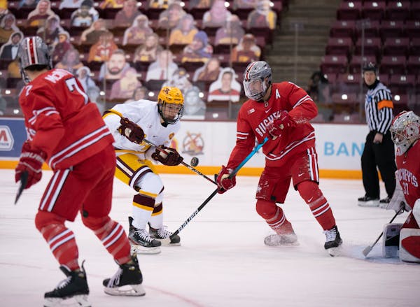 Minnesota Gophers forward Jonny Sorenson (11) kept his eye on an incoming puck in the first period, as did the Buckeyes' Grant Gabriele (61). ] JEFF W