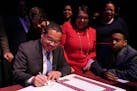 Attorney General Keith Ellison signed the paperwork to make it official after he took the oath of office at the Fitzgerald Theater in St. Paul.