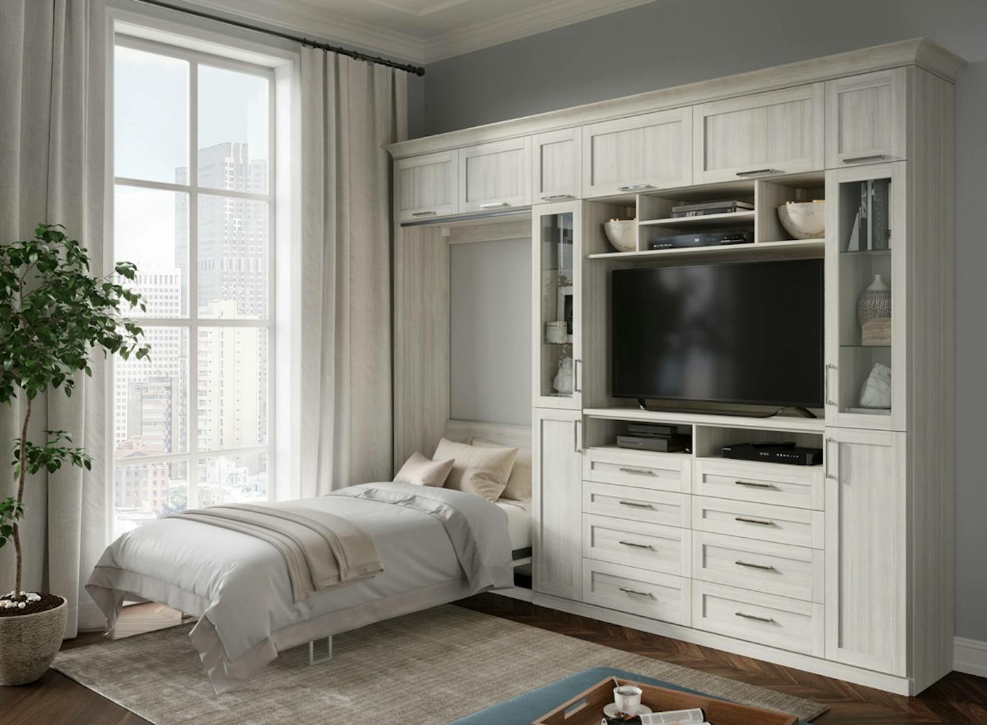 A studio apartment with a twin bed built into a white cabinet.