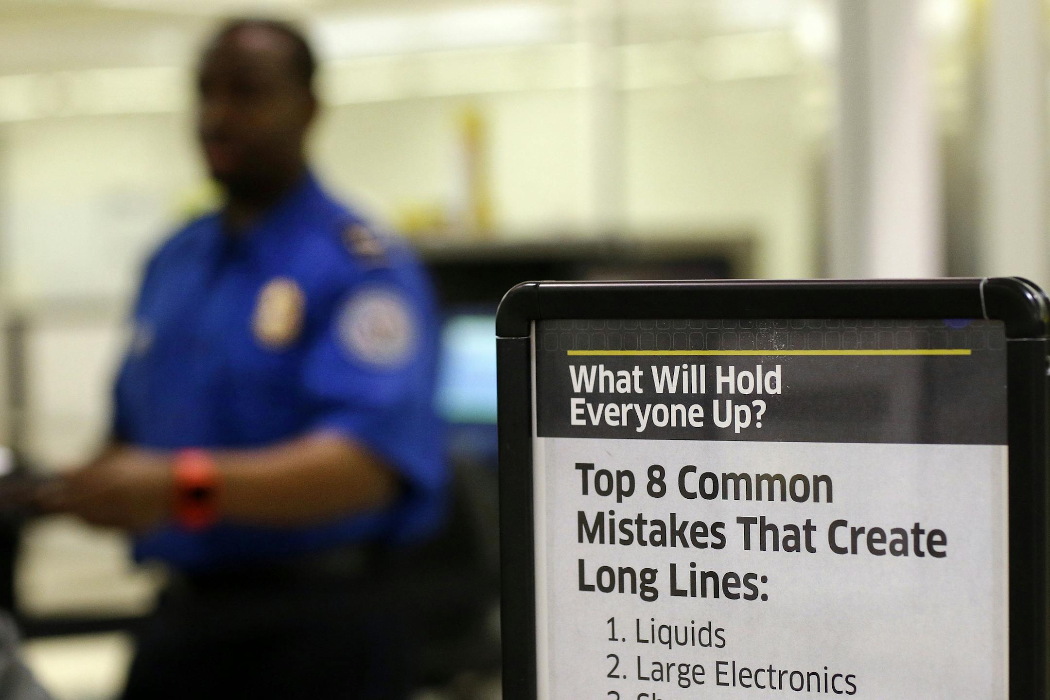 A sign greets travelers in front of a Transportation Security Administration officer at a security checkpoint at Baltimore-Washington International Thurgood Marshall Airport in Linthicum, Md., Friday March, 1, 2013. (AP Photo/Patrick Semansky)