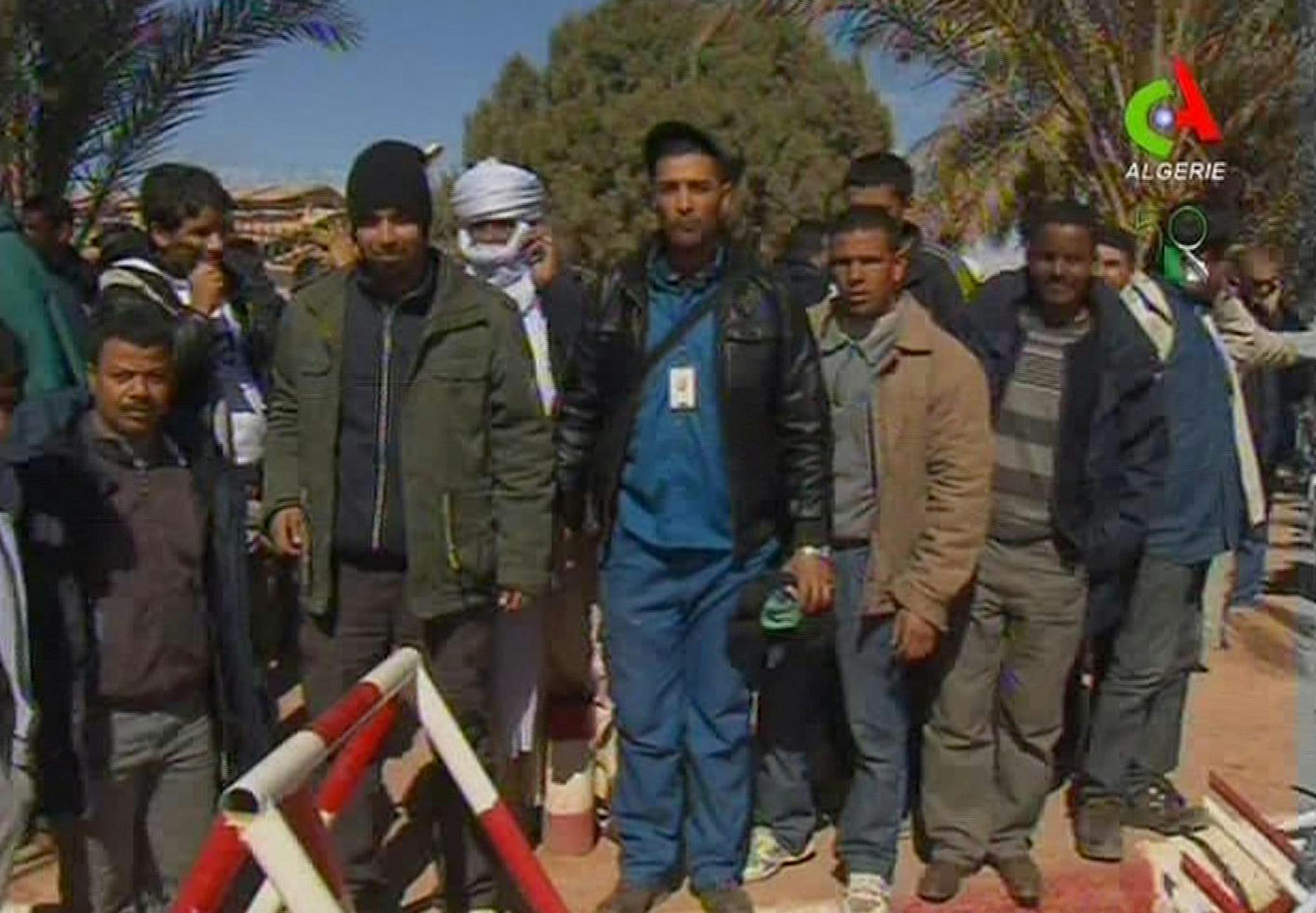 Unidentified rescued hostages pose for the media in Ain Amenas, Algeria, in this image taken from television Friday Jan. 18, 2013. Algeria's state news service says nearly 100 out of 132 foreign hostages have been freed from a gas plant where Islamist militants had held them captive for three days. The APS news agency report was an unexpected indication of both more hostages than had previously been reported and a potentially breakthrough development in what has been a bloody siege. (AP Photo/Ca