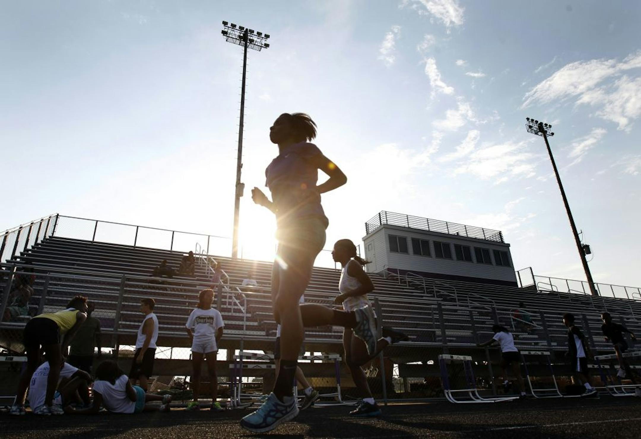 Athletes warmed up and stretched out before a recent practice at Brooklyn Center High School. High school stars are in short supply on the summer track and field circuit. Photo by Carlos Gonzalez • cgonzalez@startribune.com