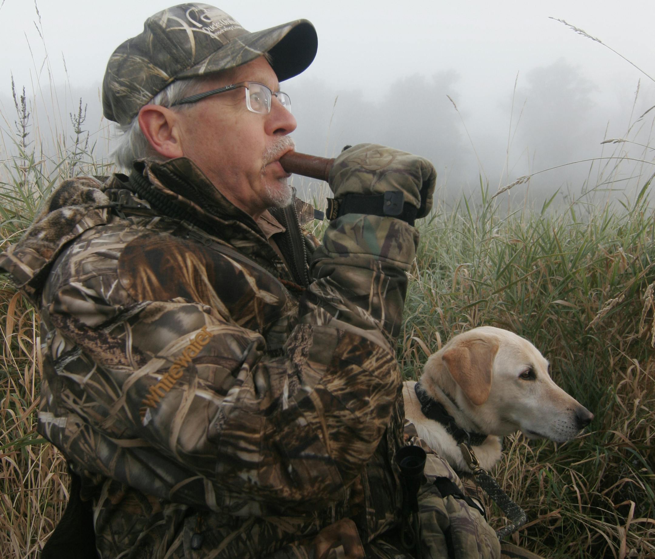 Doug Smith/Star Tribune; Sept. 13, 2014, near Zimmerman, Minn. Brian Ross of Brainerd calls ducks during Youth Waterfowl Day on a foggy morning Saturday on the Sherburne National Wildlife Refuge. Ross, accompanied by his yellow Lab, Fritz, mentored two youths during the hunt.