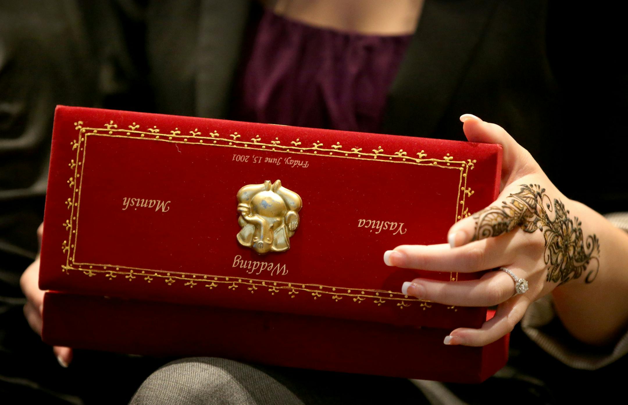 JW Marriott at the Mall of America held a cultural training for employees that focused mostly on Indian Weddings where the average cost in the U.S. is $250,000. Melanie Olaes, JW Marriott housekeeping manager, her hand freshly painted with henna, looked over a box that had held a wedding announcement for an Indian couple during the training Thursday, May 26, 2016, at the JW Marriott at the Mall of America in Bloomington, MN.](DAVID JOLES/STARTRIBUNE)djoles@startribuneMarriott International began