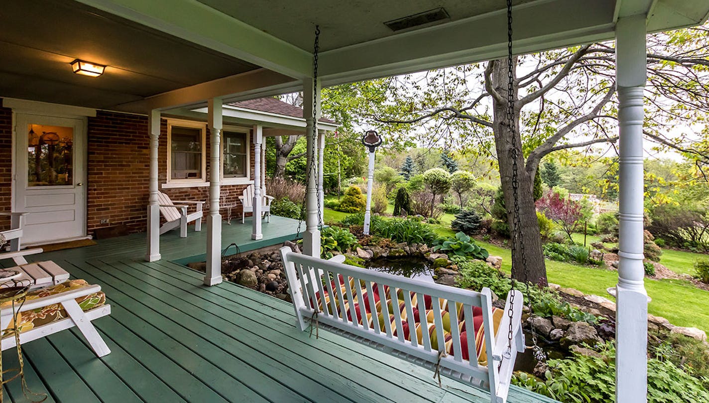 The veranda of the American Eagle Bluff Bed & Breakfast in Reads Landing overlooks a fish pond and acres of gardens and fruit trees.