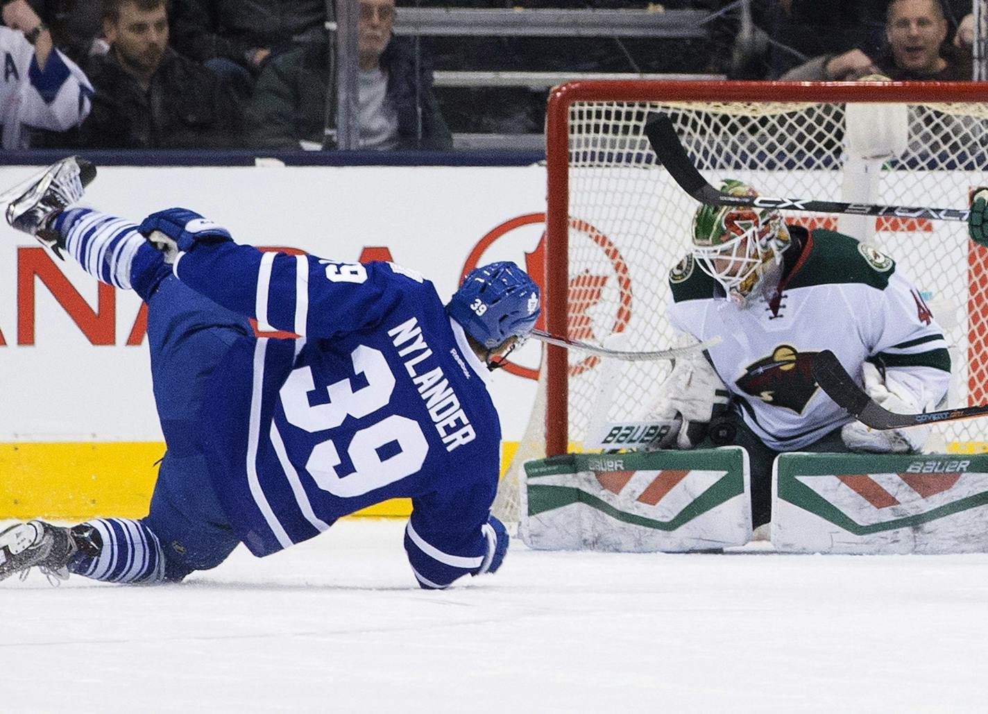 Minnesota Wild goaltender Devan Dubnyk, right, makes a save against Toronto Maple Leafs' William Nylander during first-period NHL hockey game action in Toronto, Thursday, March 3, 2016. (Chris Young/The Canadian Press via AP) MANDATORY CREDIT