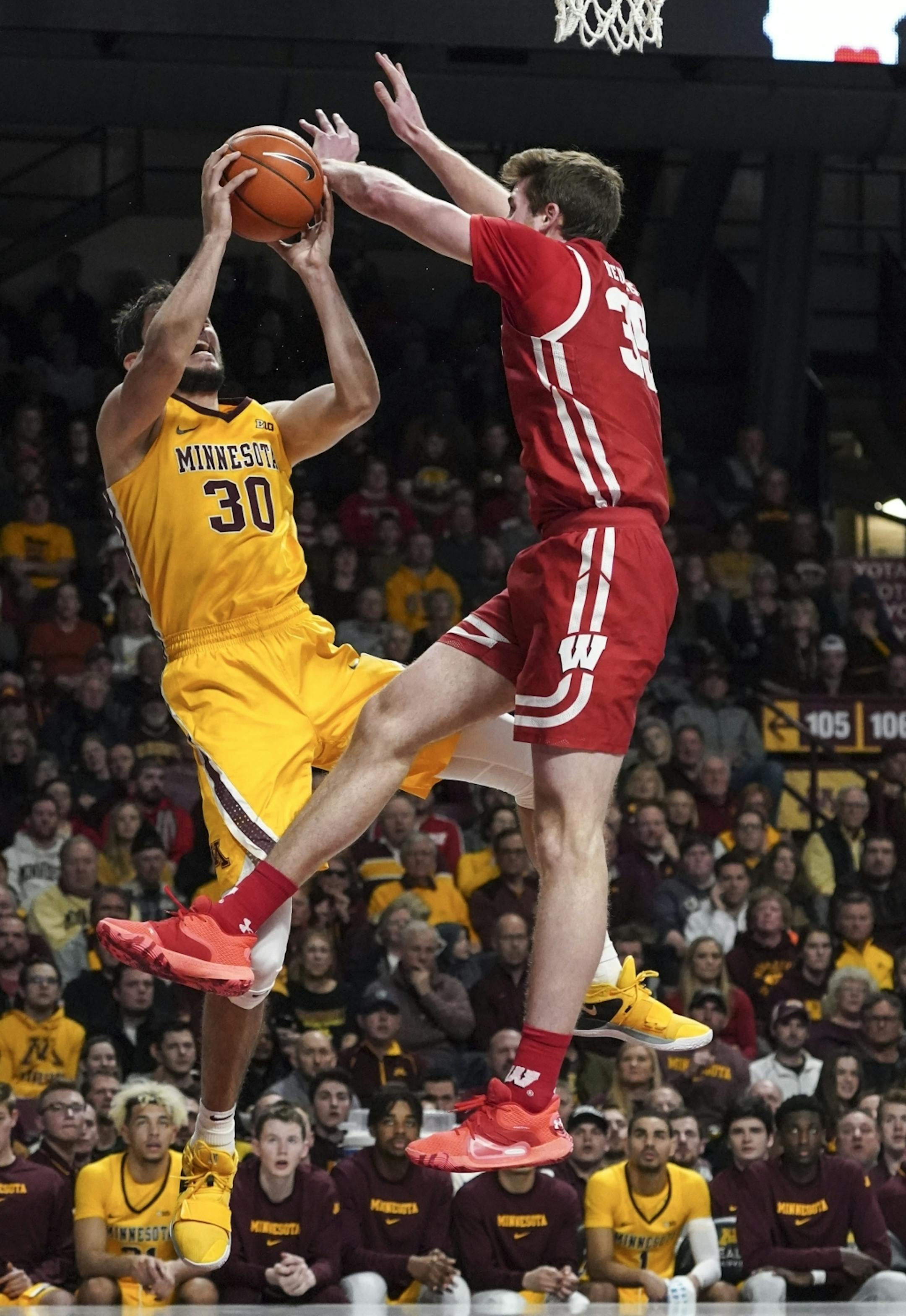 Minnesota Gophers forward Alihan Demir (30) was blowed by Wisconsin Badgers forward Nate Reuvers (35) in the second half. A foul was called on Wisconsin.