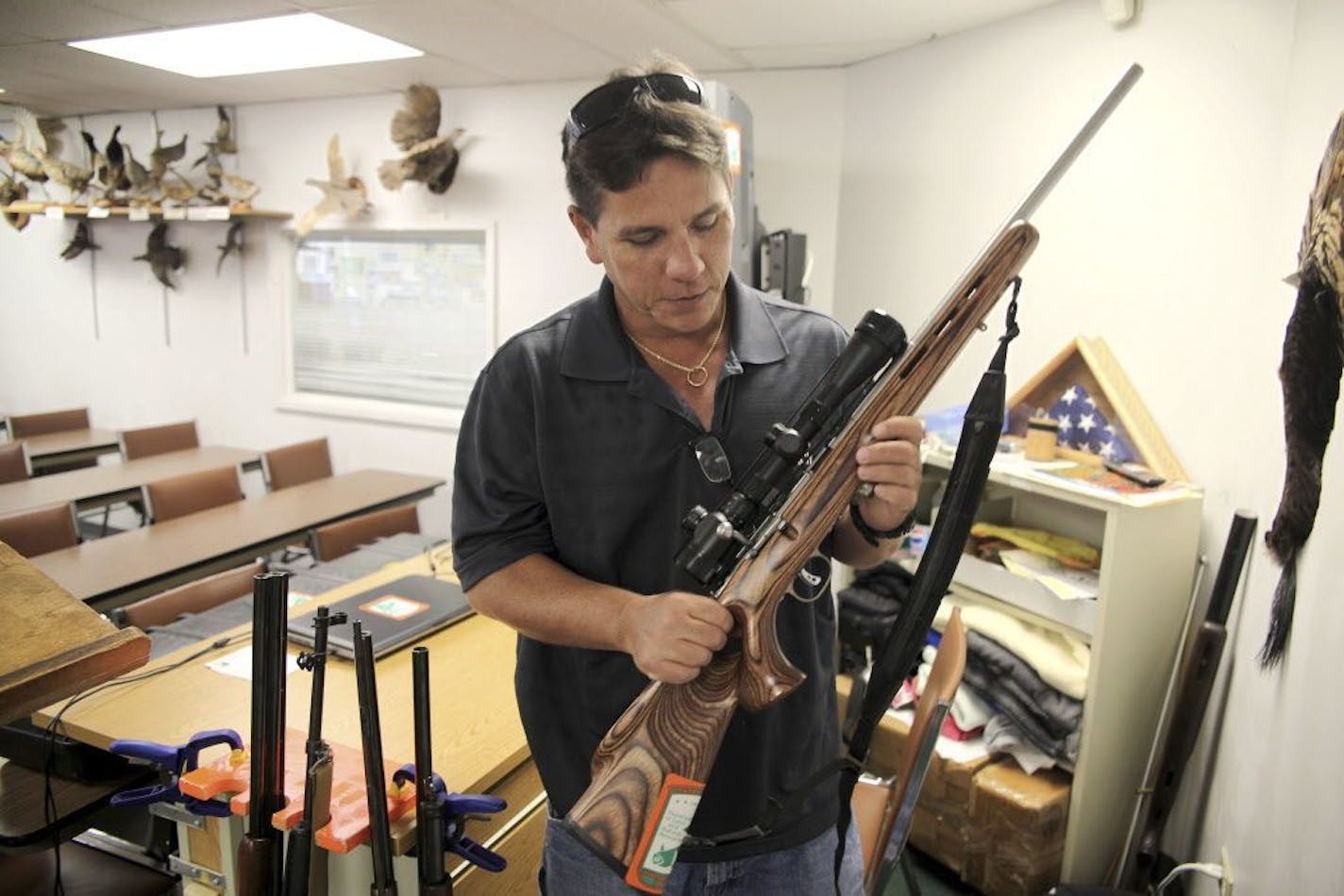 FILE - In this May 10, 2016, file photo, Jerry Ilo holds a gun that he uses to teach the Hawaii Department of Natural Resources hunter education training course in a classroom in Honolulu. Ilo was one of several Hawaii residents to speak out against a bill passed by lawmakers to allow Hawaii gun owners to be registered in a federal database that will automatically notify police if an island resident is arrested anywhere else in the country.