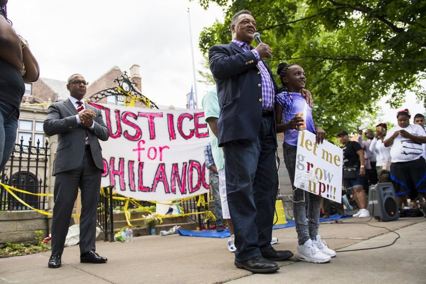 Jesse Jackson stood with Zenayzia Crite, 8, as he spoke to the crowd outside the governor's residence in St. Paul on Friday.