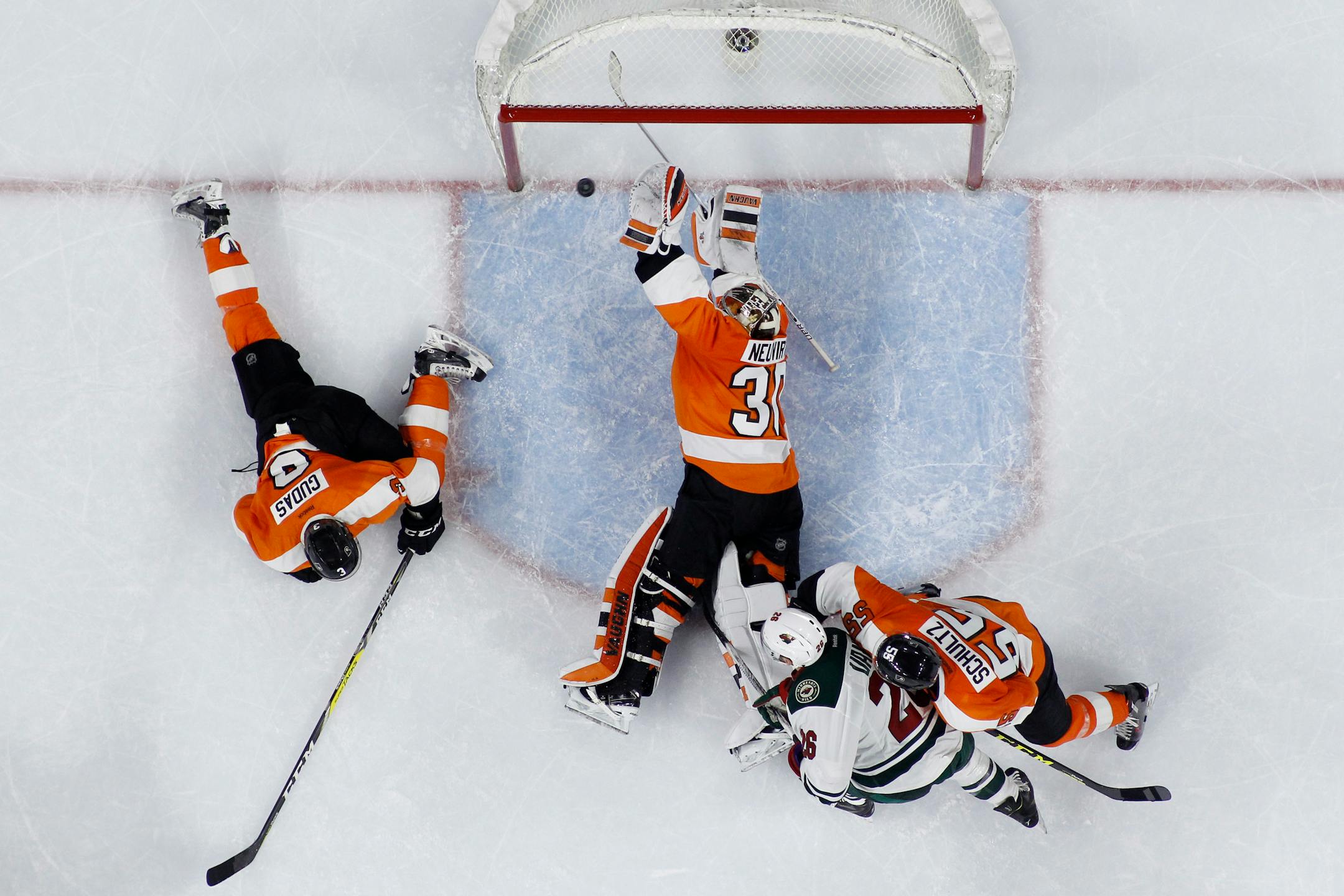 Philadelphia Flyers' Michal Neuvirth (30) blocks a shot by Minnesota Wild's Charlie Coyle past Radko Gudas (3), Nick Schultz (55) and Thomas Vanek (26) during the final seconds of an NHL hockey game, Thursday, Feb. 25, 2016, in Philadelphia. Philadelphia won 3-2. (AP Photo/Matt Slocum)