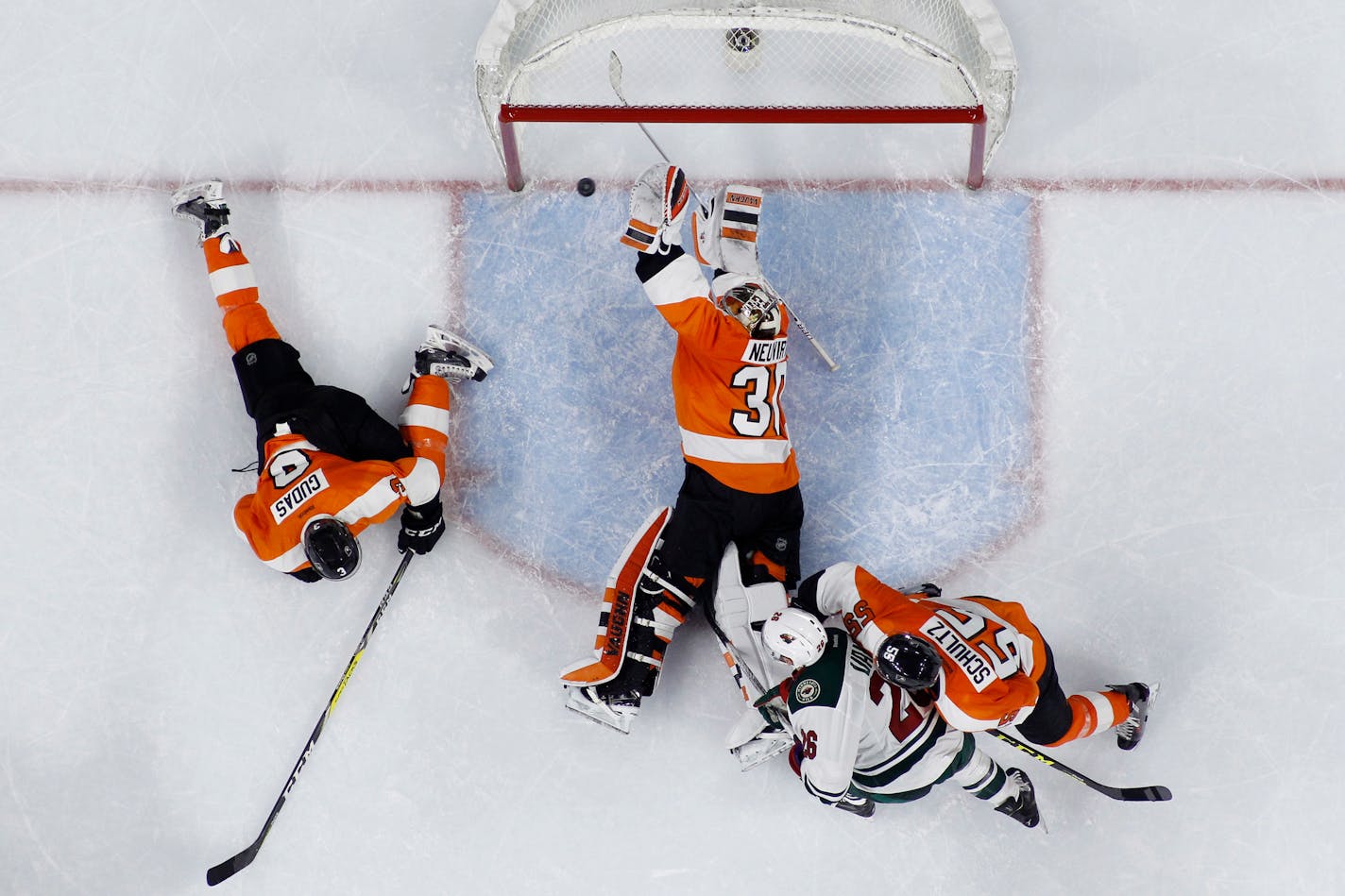 Philadelphia Flyers' Michal Neuvirth (30) blocks a shot by Minnesota Wild's Charlie Coyle past Radko Gudas (3), Nick Schultz (55) and Thomas Vanek (26) during the final seconds of an NHL hockey game, Thursday, Feb. 25, 2016, in Philadelphia. Philadelphia won 3-2. (AP Photo/Matt Slocum)