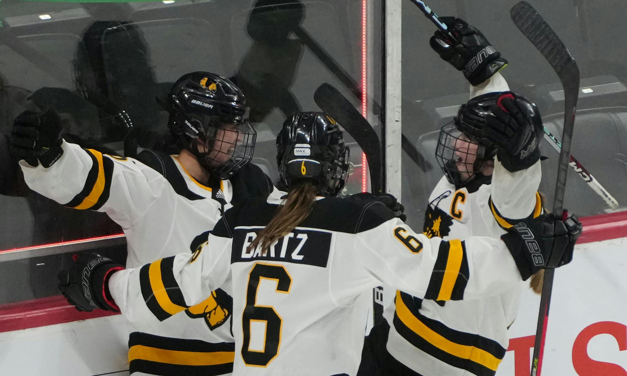 Warroad forward Kate Johnson (16), forward Rylee Bartz (6) and forward Talya Hendrickson (13) celebrate after Johnson scored her second goal in the third period.