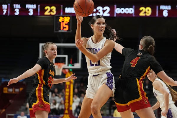 Goodhue guard Elisabeth Gadient (25) passes over Mountain Iron-Buhl guard Jordan Zubich during Saturday's Class 1A title game at Williams Arena.